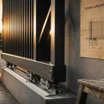 Schéma d'un portail autoporté : rail intégré et chariots à galets sur béton
